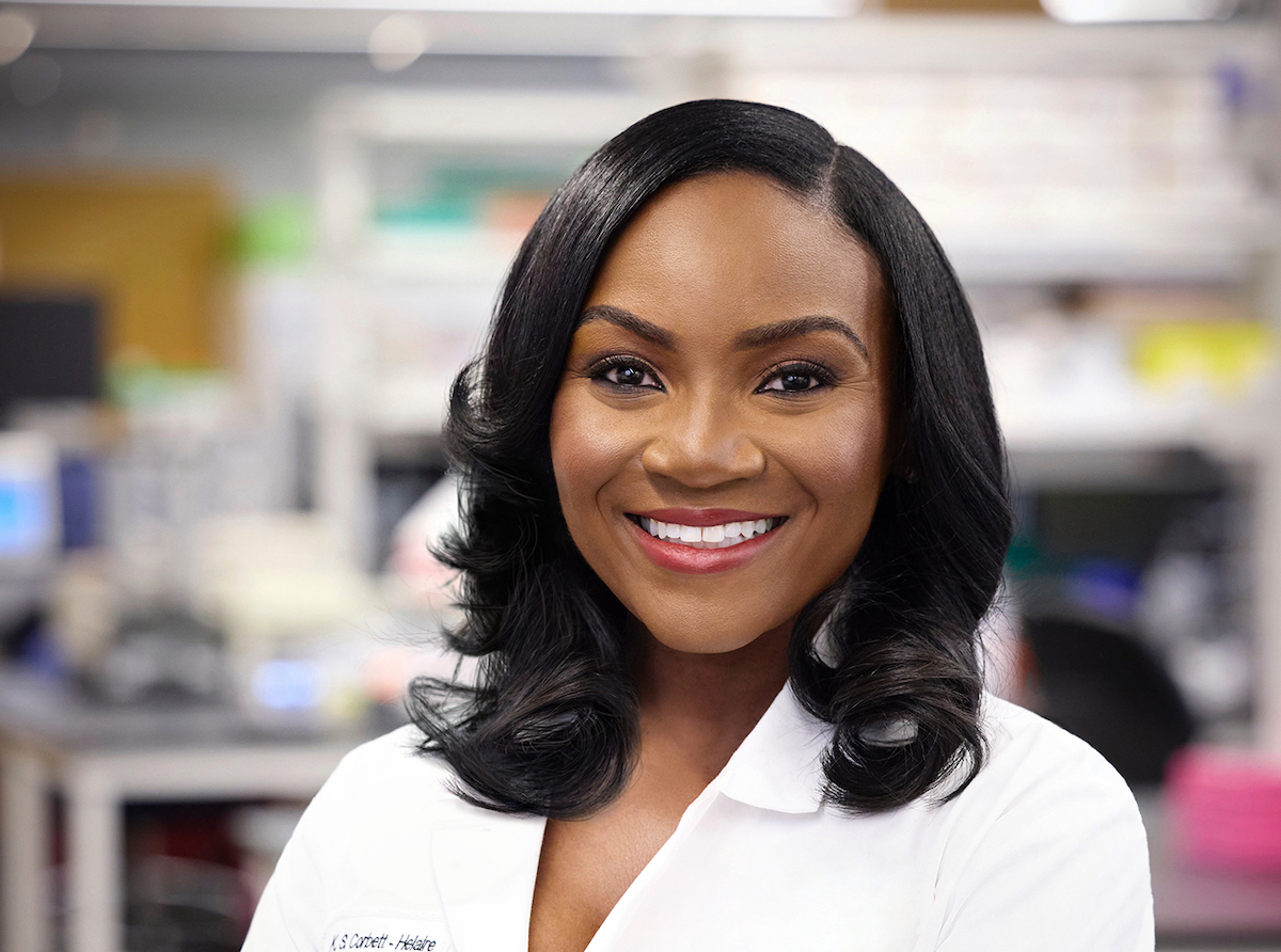 A Black woman wearing a lab coat in a lab.