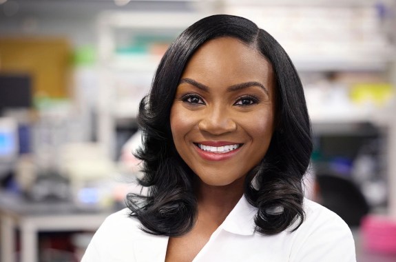 A Black woman wearing a lab coat in a lab.