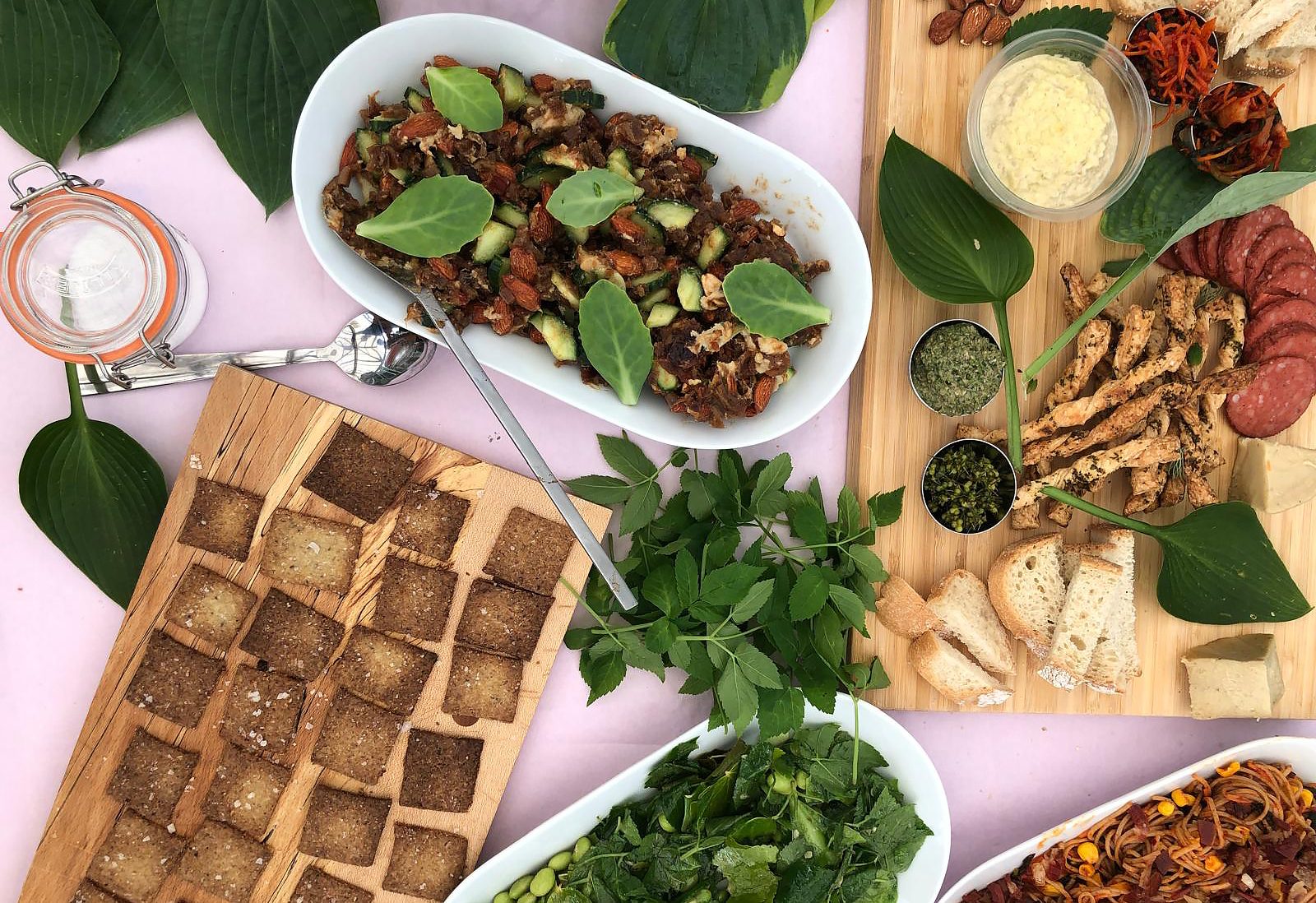 Looking down at a tabletop with trays of various foods.