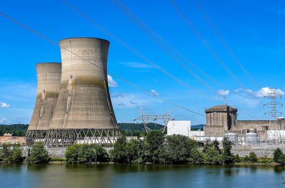 A nuclear power plant, large buildings like concave cylinders by a body of water.