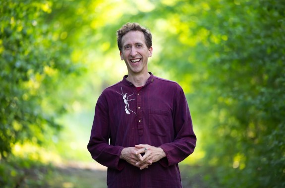 A smiling man who looks thrilled to be wearing a shirt with a bug on it.