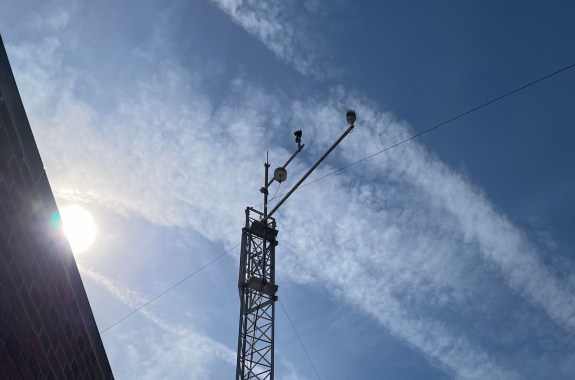 A tower with instruments sticking off of it against a blue sky
