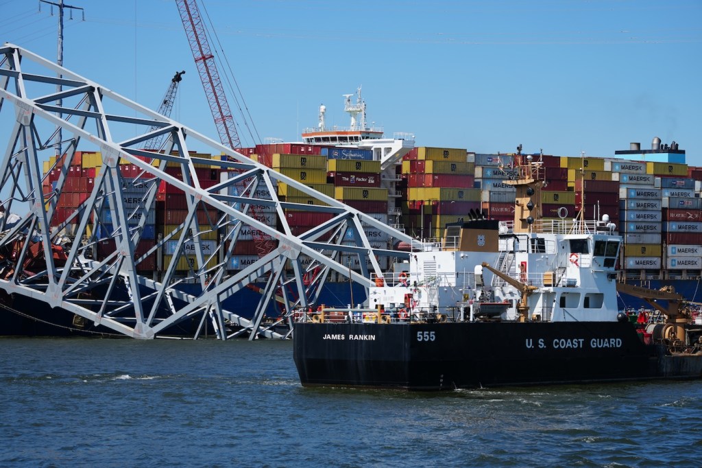 Two boats surrounding a collapsed bridge