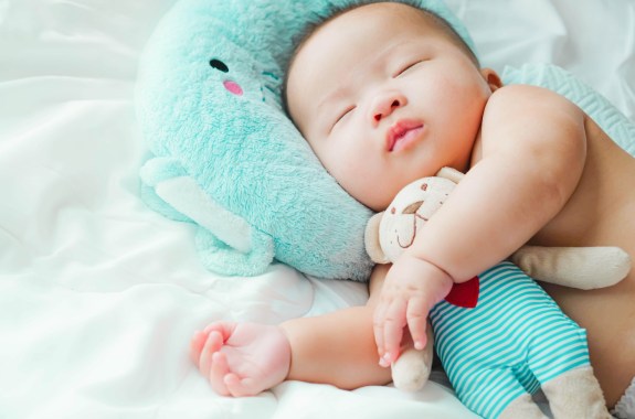 A newborn baby boy 4 months old Sleep and hugs a teddy bear,