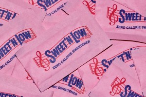 Sweet 'N Low packets scattered loosely, full frame macro image. Artificial sweetener and sugar substitute, it is made by Cumberland Packing Corporation in the USA.