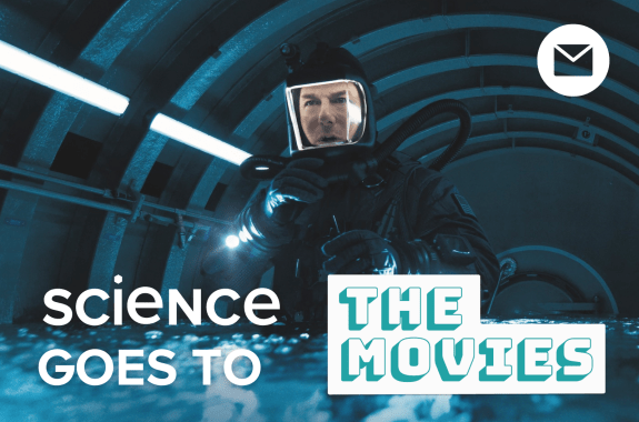 Actor Tom Cruise looking perplexed while in a diving suit in a small space flooded with water.