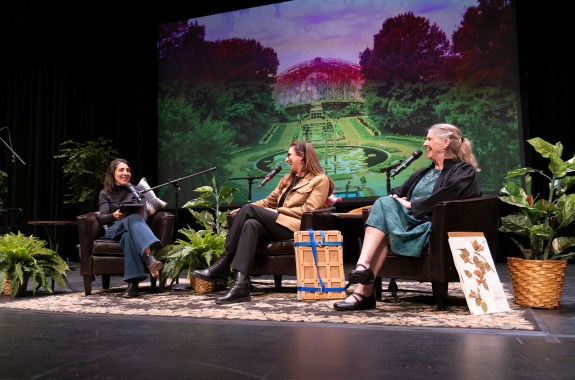 A panel of people talking with a picture of the missouri botanic gardens