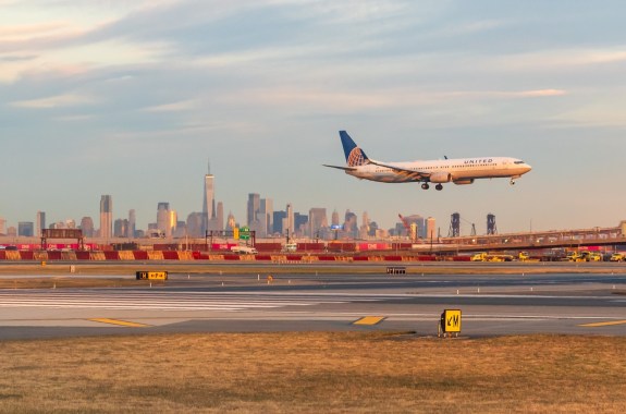 USA - October 31, 2024 - United Airlines Jet landing at Newark Liberty Airport at golden hour with the Lower Manhattan skyline in the background