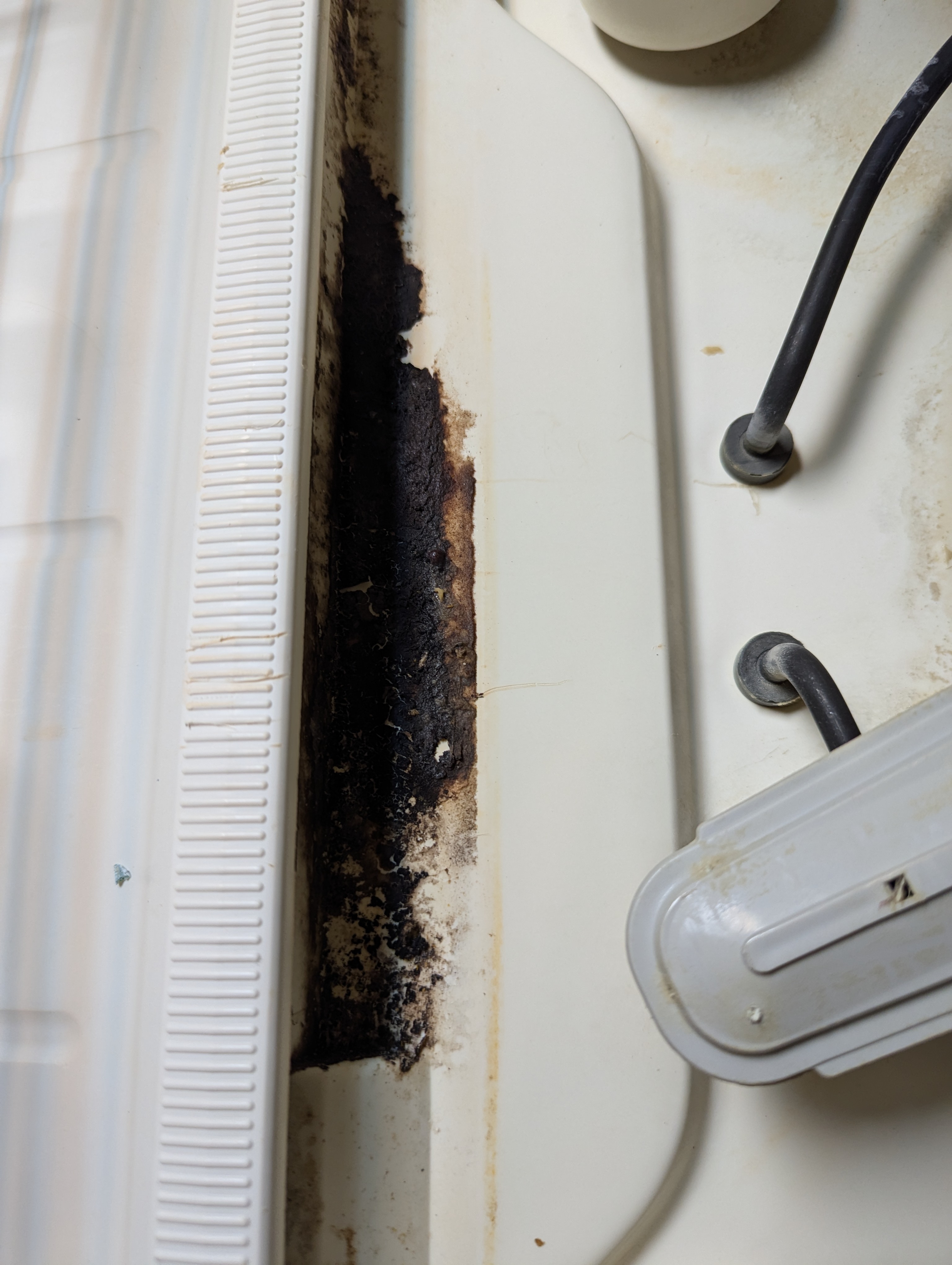 Black gunk between a windowsill and an AC.