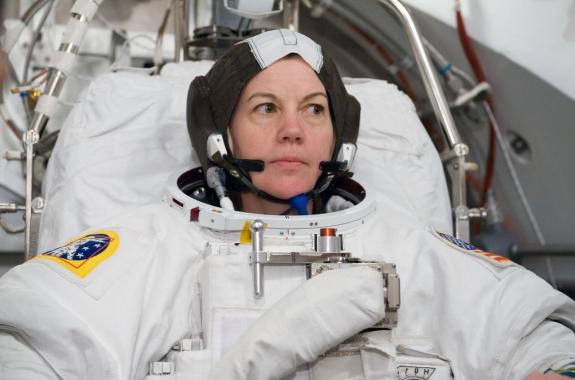 A woman looking concerned in an astronauts uniform.