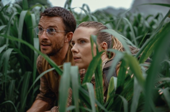 A man and woman crouching in very tall grass