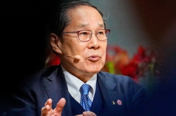 Masao Tomonaga wearing a microphone speaking.