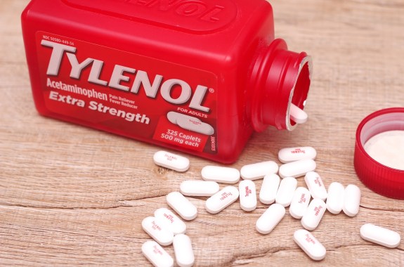 WASHINGTON, USA - October 15, 2022: Bottle Of Tylenol Extra Strength With Many Pills On A Wooden Table Which Was Sold Out During Covid-19 time, headache, Painkillers.